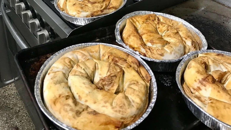 Aluminum pans of burek on a stove