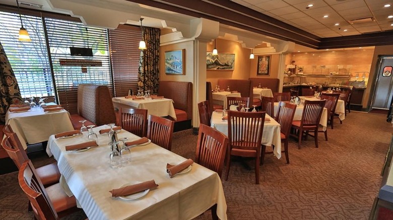 Restaurant dining room with white tablecloths and wooden chairs