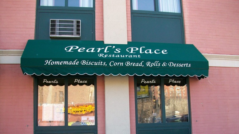 Red brick restaurant exterior with a green sign