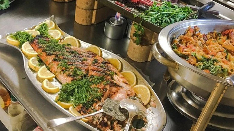 Buffet of fish and vegetables on a metal table