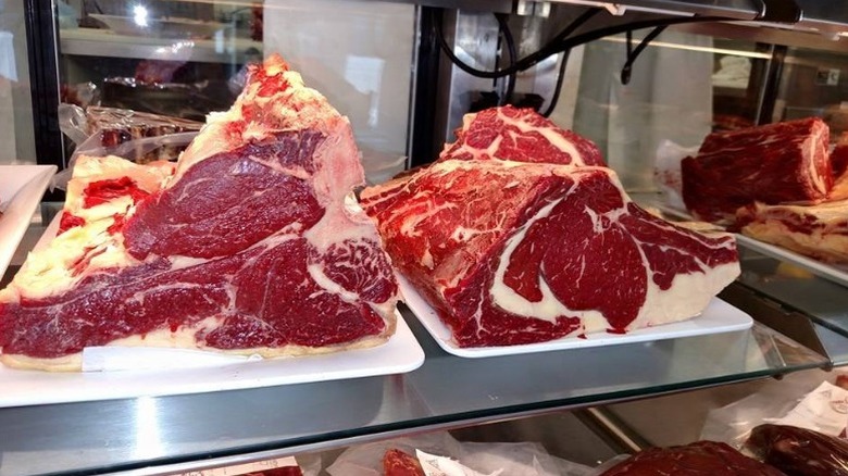 Two large fresh cut rib roasts in butcher case.