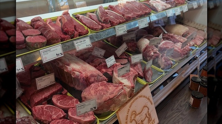 Butcher shop display case with fresh cuts of meat.