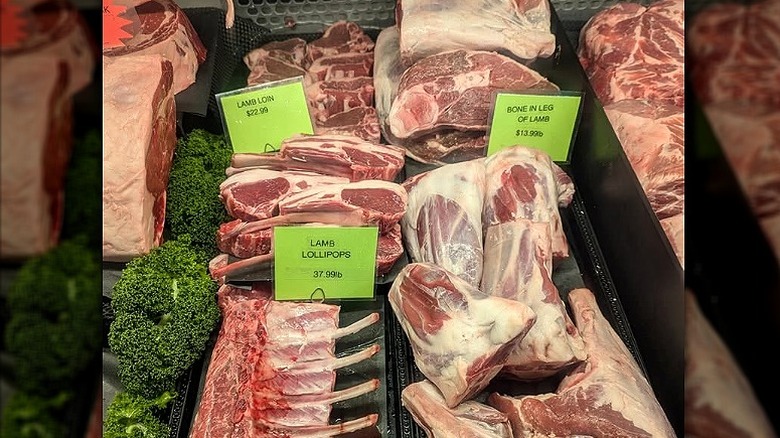 Fresh cuts of lamb in butcher shop display case.