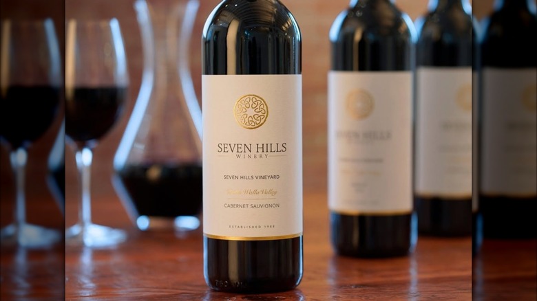 Bottle of Seven Hills Winery Walla Walla Valley Cabernet Sauvignon with carafes in the background