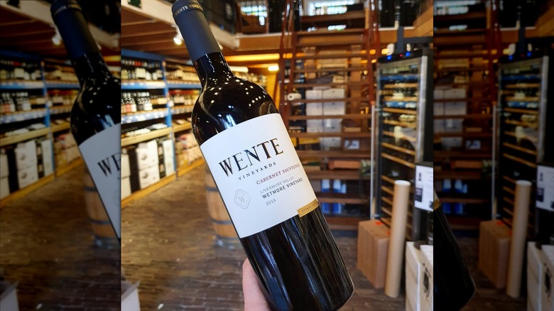 Hand holding a Wente Wetmore Vineyard Cabernet Sauvignon bottle in a wine shop