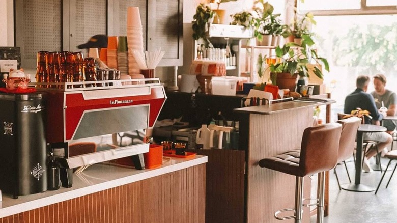 Interior of Batch Baby with red coffee machine, high stools and wooden counters