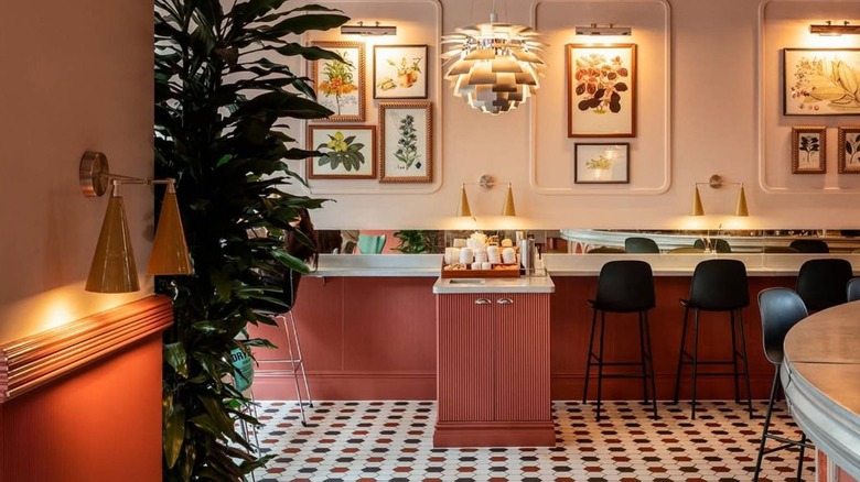 Danish-style interior of Hagen Espresso Bar in London with framed posters, lighting fixtures, plants and patterned flooring
