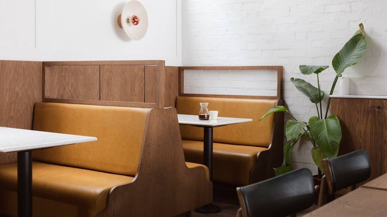 Image of brown booths and a plant at Prufrock Coffee