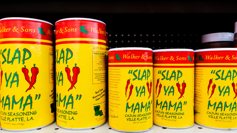 Cans of Slap Ya Mama Cajun seasoning on the shelf