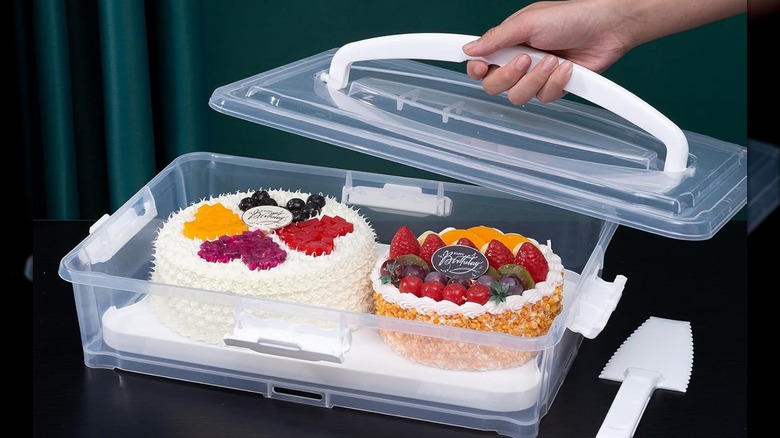 A person lifting the lid to a Feeoowv cake carrier