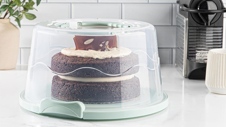 A MosJos cake carrier on the counter with a cake