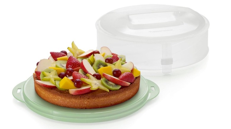 A Tupperware collapsibe cake carrier with a fruit cake