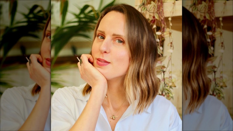 A three tier wedding cake with flower petals and bumblebees.