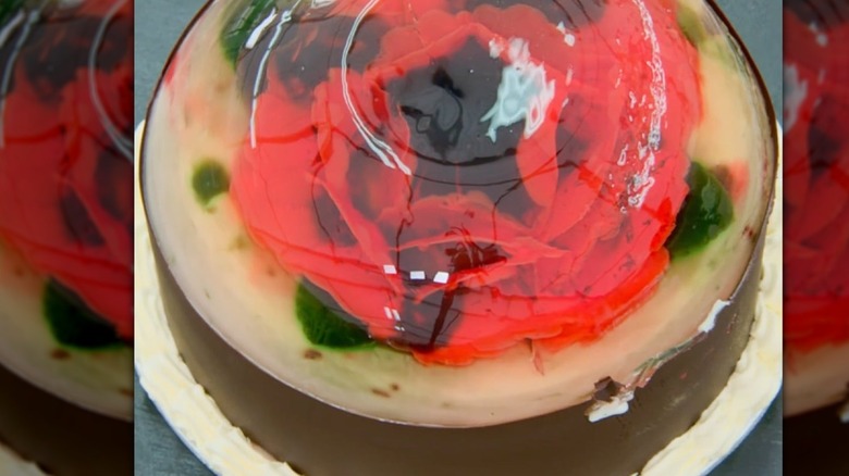 A red floral jelly cake on top of a table.