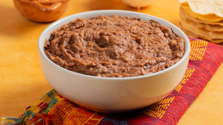 refried beans in bowl with tortillas