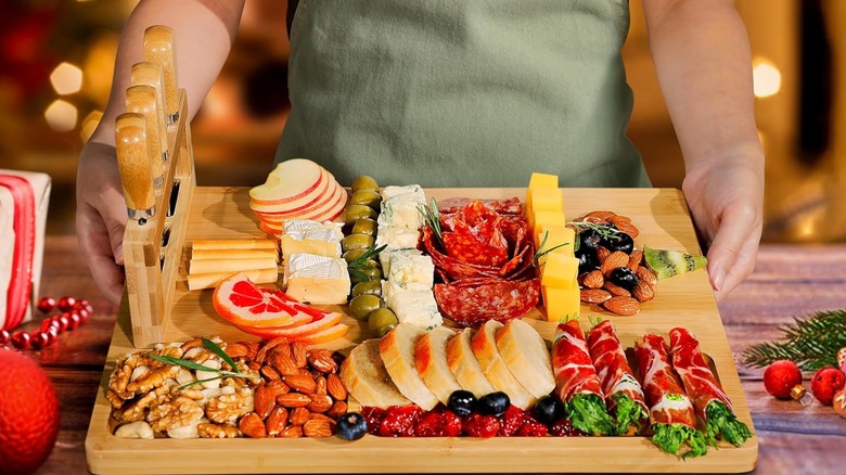 A person holding an Easoger charcuterie board