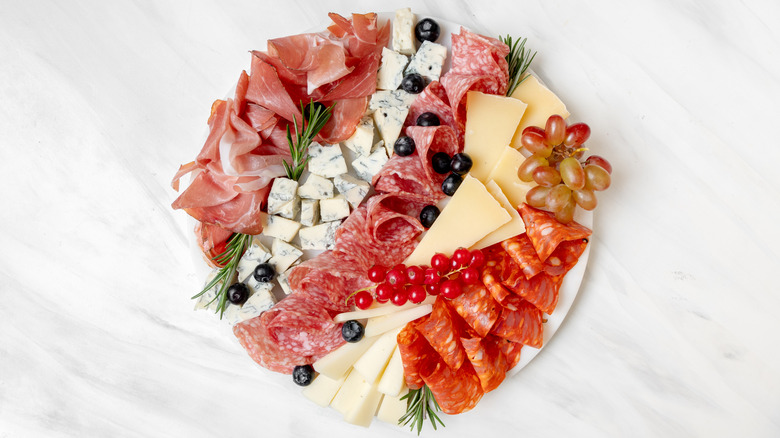 A round charcuterie board with cheese and meats