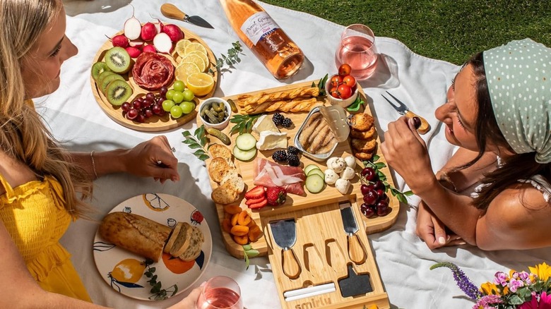 Friends sharing meats and cheeses on the Smirly charcuterie board