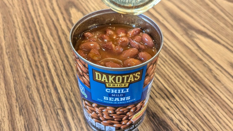 Top view of open can of chili beans on wood table