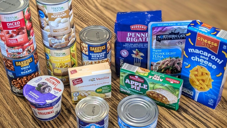 Various Aldi products like cans, boxes, and bags arranged on a wooden table