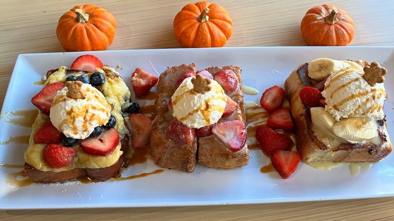 Plate with three pieces of French toast with ice cream and strawberries