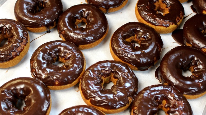 Chocolate-covered donuts on white background