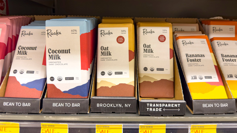 Raaka chocolate in coconut milk, oat milk, and bananas Foster flavors on a grocery store shelf