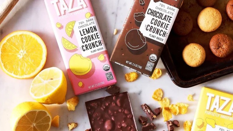 Various Taza Chocolate bars surrounded by fresh lemons, cornflakes, and freshly baked muffins