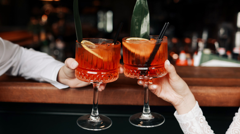 Two people holding Spritz cocktails