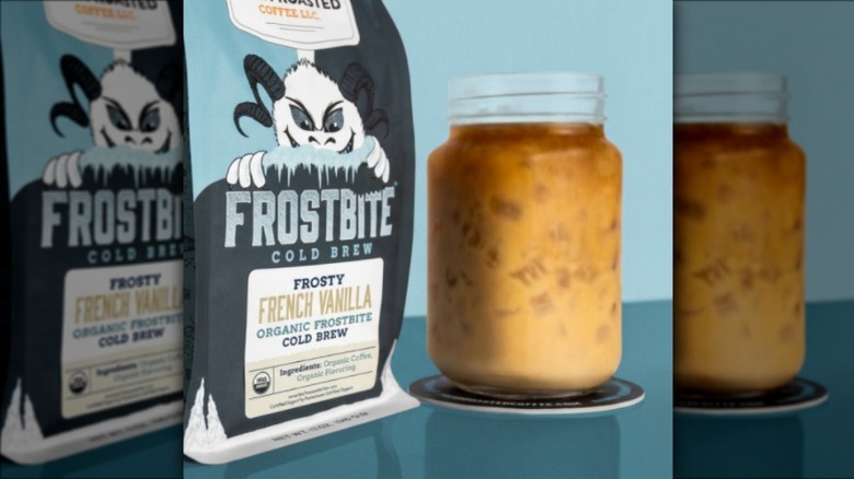 Bag of Frostbite Frosty French Vanilla Cold Brew Coffee on blue background next to jar of iced coffee