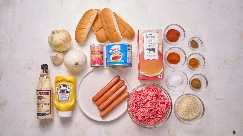 Hot dogs, buns, ground meat, onions, and other Coney Island hot dog ingredients on a table