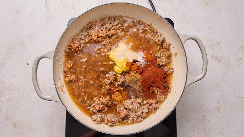 Aerial view of pot of beef seasoned with spices and mustard