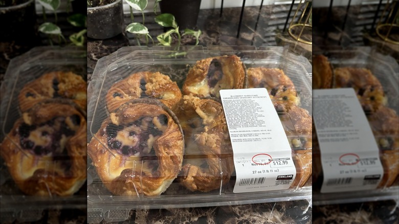 A box of 6 count blueberry cheesecake caramelized croissant placed on a granite kitchen countertop