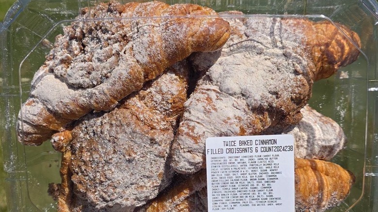 A 6 count box of twice baked cinnamon filled croissants against a green grass background