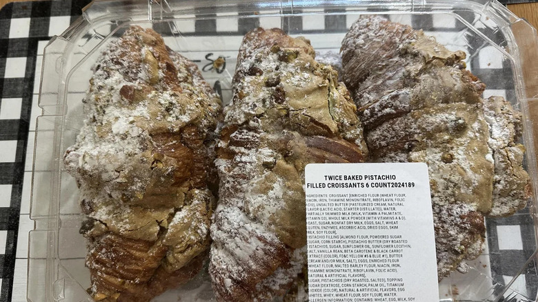 A 6 count box of twice baked pistachio filled croissants placed on a checkered table