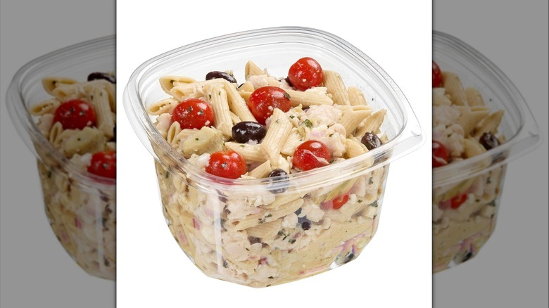 A plastic tub of Kirkland Signature Greek Pasta Salad with Rotisserie Chicken and Dressing