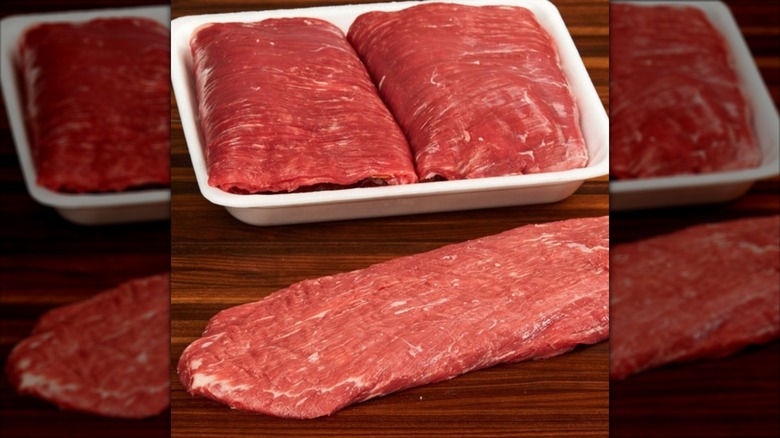 Two Kirkland Signature Flank Steaks in white tray next to third flank steak