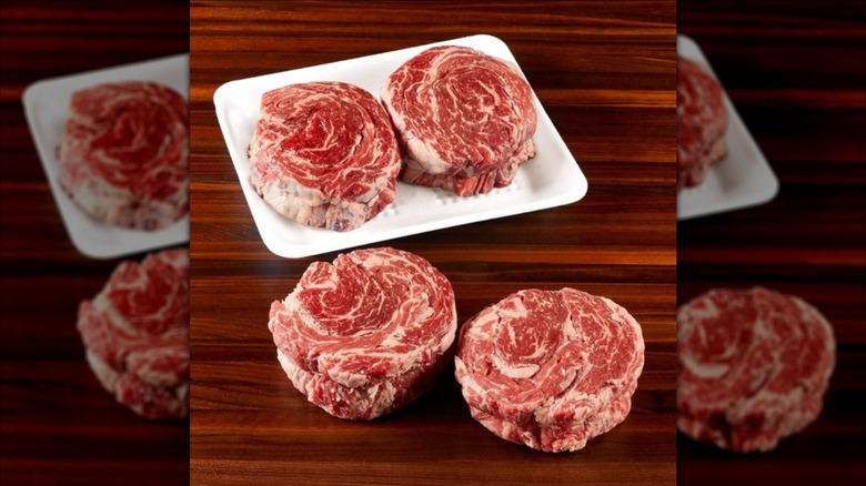 Four Kirkland Signature Prime Boneless Ribeye Cap Steaks on wooden table