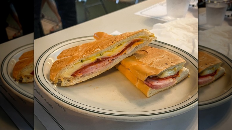 Cuban sandwich from Versailles in Miami cut in half and served on a white plate
