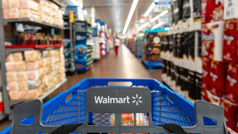 a first person view of a shopping cart in an aisle at Walmart