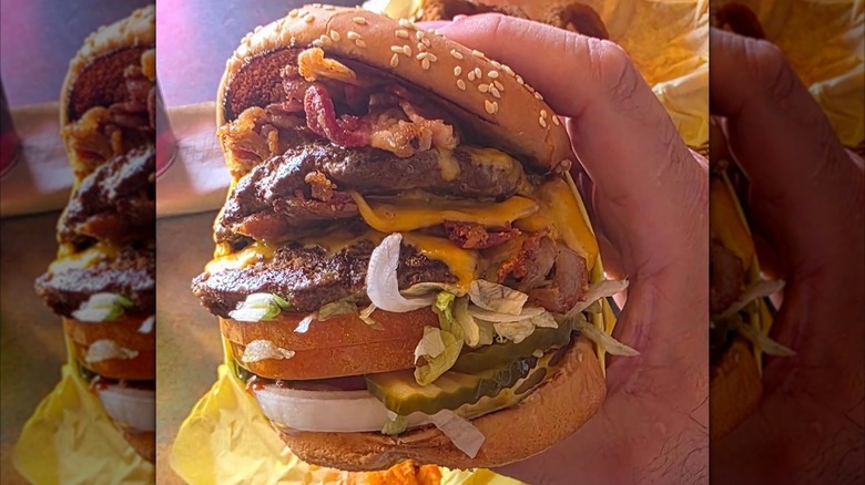 Hand holding a massive burger at Hodad's