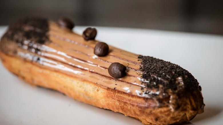 close up shot of a coffee eclair with chocolate on top