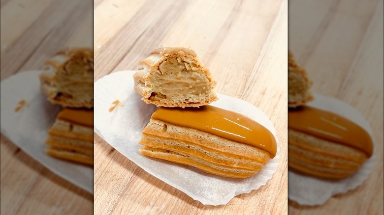 coffee eclair cut in half, showing the cream on inside