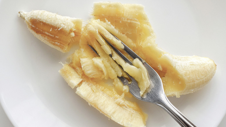 Bananas with fork and white plate