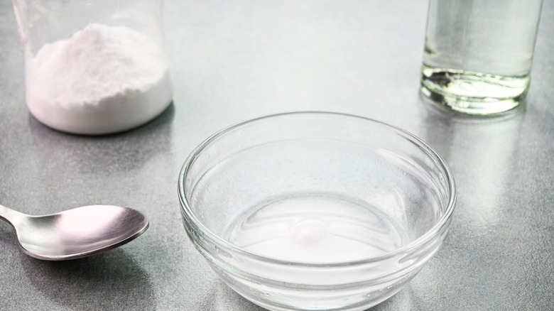 Bowl with vinegar and baking soda in background
