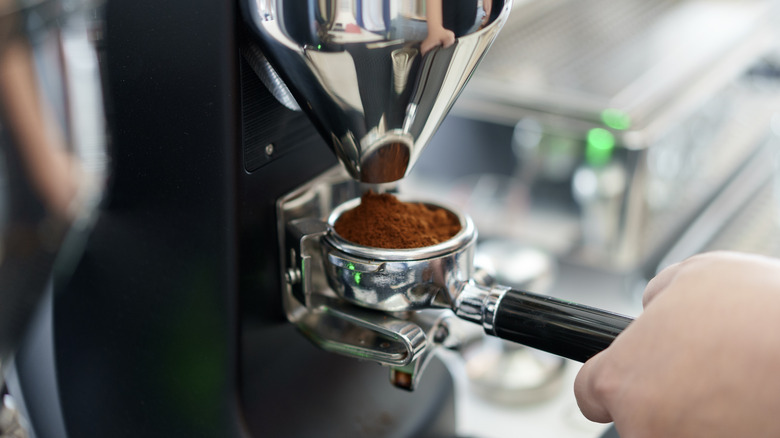 Close-up of an espresso machine with a barista making coffee
