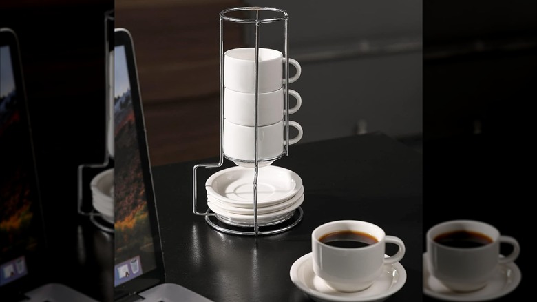 Sweese espresso cups with their holder on a desk, with one cup full of coffee