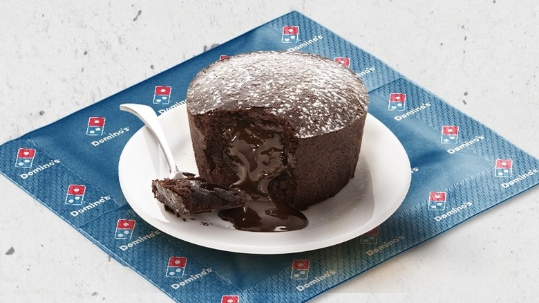 Domino's chocolate lava cake on white plate, with chocolate sauce oozing out