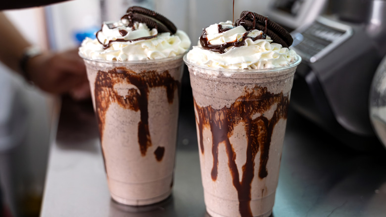 Chocolate milkshakes sitting inside a fast food restaurant