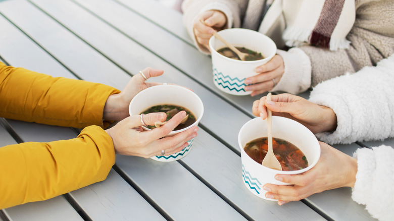 paper cups with soup at restaurant